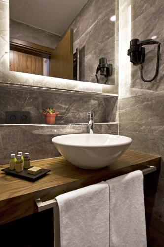a bathroom with a white bowl sink on a wooden counter at Snog Rooms & Suites in Istanbul