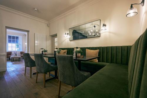 a dining room with a table and green chairs at Wilding Hotel in Brough