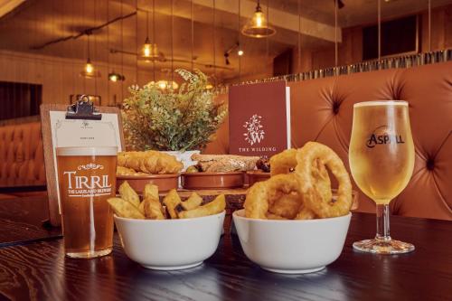 a table with two bowls of onion rings and a glass of beer at Wilding Hotel in Brough