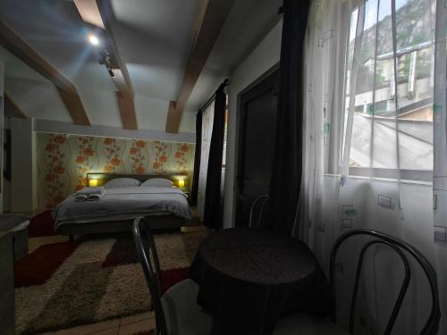 a small bedroom with a bed and a window at Casa Miclau in Băile Herculane