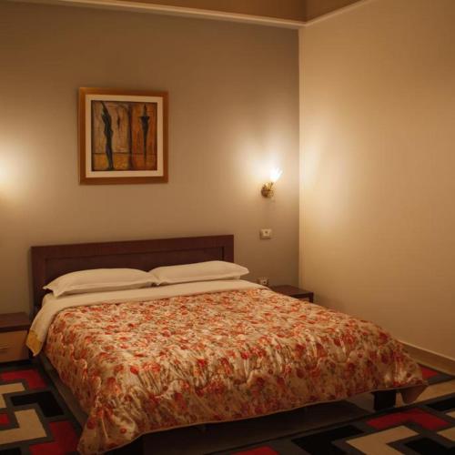 a bedroom with a bed with a comforter at Grand Hotel in Elbasan