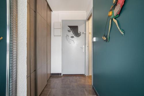 un couloir avec une porte sur laquelle est peint un visage dans l'établissement Cap Venus naturiste, au Cap d'Agde