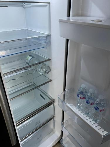 an open refrigerator with bottles of water in it at Three Kings Luxe Escape in London