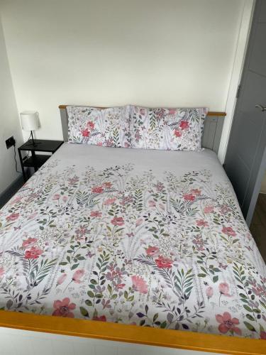 a bed in a bedroom with a floral bedspread at Three Kings Luxe Escape in London