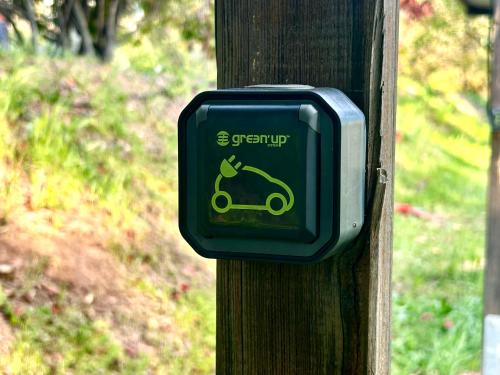 a green sign on a wooden post with a scooter on it at Domaine Plan des Devens in Roussillon