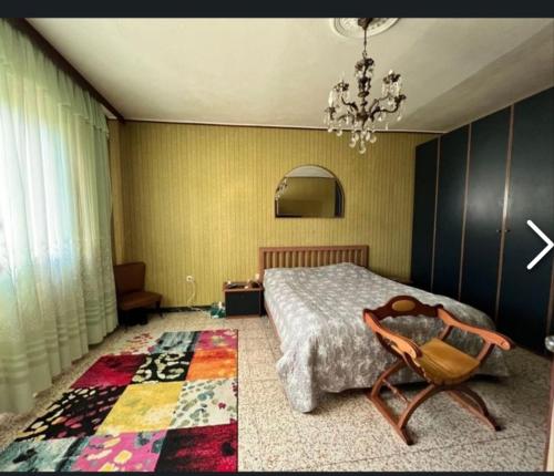 1 dormitorio con 1 cama, 1 silla y 1 alfombra en Włoski dom., en Case Matte