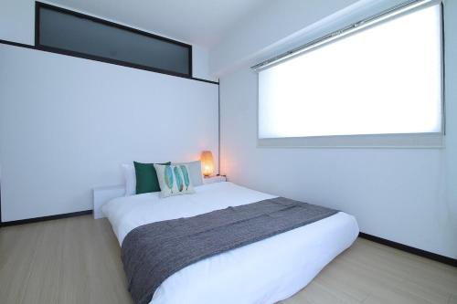 a bedroom with a white bed and two windows at Mitao bld - Huge 2 bedroom Apt 4mins walk PeacePark 6ppl in Hiroshima