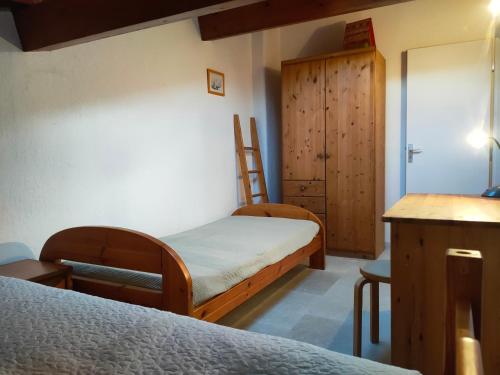 a bedroom with two beds and a wooden cabinet at Les Arbousiers in La Croix-Valmer