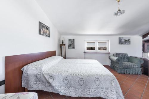 una camera con letto, divano e sedia di La Mansarda by BarbarHouse ad Avetrana