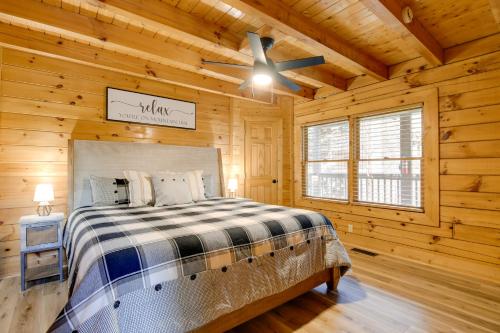 a bedroom with a bed in a log cabin at Pigeon Forge Vacation Rental with Private Hot Tub! in Pigeon Forge