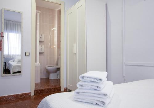 a pile of towels sitting on a bed in a bathroom at Barcelona City Street in Barcelona