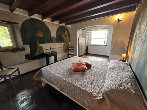 een slaapkamer met een bed met een oranje kussen erop bij Residenza la Torre in Reno Di Leggiuno