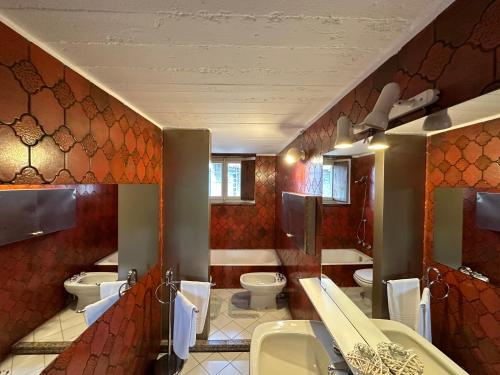 een badkamer met meerdere wastafels en toiletten. bij Residenza la Torre in Reno Di Leggiuno