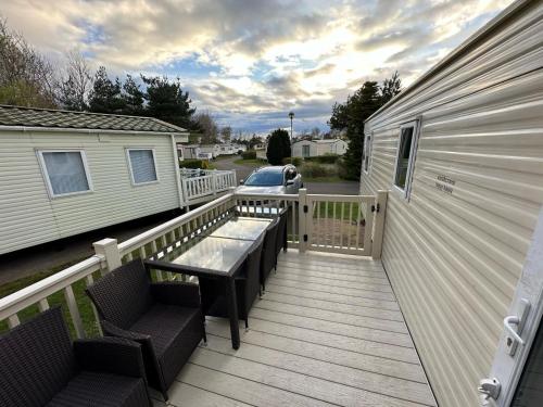 a wooden deck with a table and chairs on a house at Caravan Turnberry 2 in Port Seton