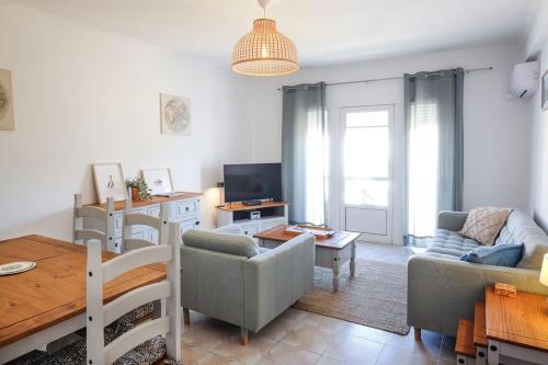 a living room with a couch and a table at Casa Buganvilia in Tavira