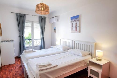 a bedroom with a large bed and a window at Casa Buganvilia in Tavira