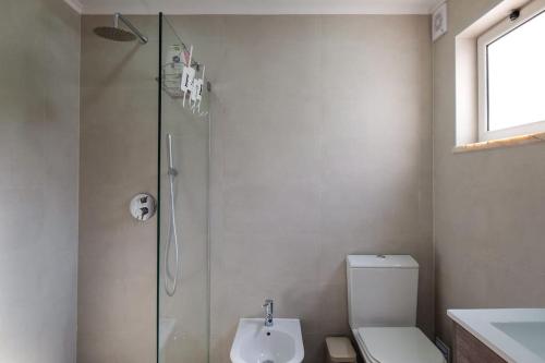 a bathroom with a shower and a toilet and a sink at Casa Buganvilia in Tavira