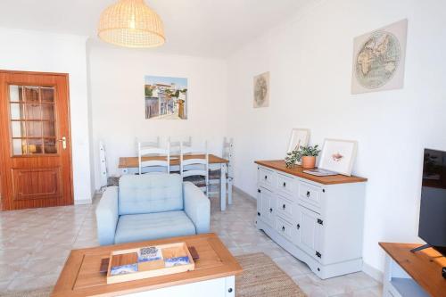 a living room with a blue chair and a table at Casa Buganvilia in Tavira