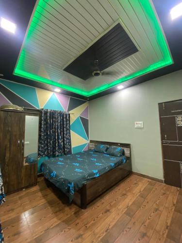 um quarto com uma cama com iluminação verde em Jai mata dee farm house em Vajapūr