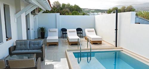 einen Balkon mit einem Pool, Stühlen und einem Tisch in der Unterkunft Arokaria Holiday Houses in Platanes