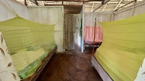 a room with two beds with green sheets at Campamento Txoko de Shapshico in Puerto Franco