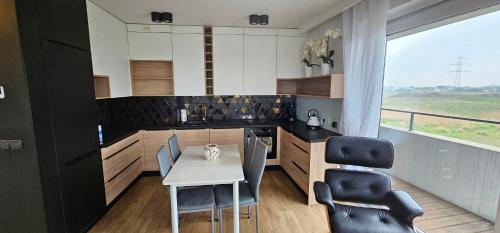 a kitchen with a table and chairs and a window at Apartamenty Natura in Opole