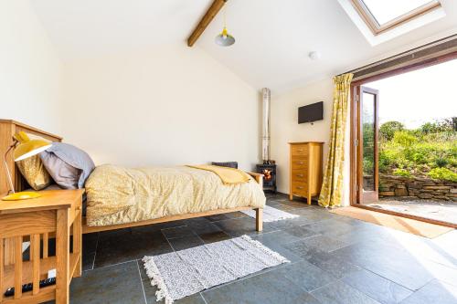a bedroom with a bed and a large window at Cornwall cottage The Old Piggery in Liskeard