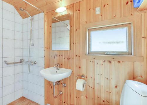 a bathroom with a sink and a toilet and a window at Camping Vesterhav in Harboør