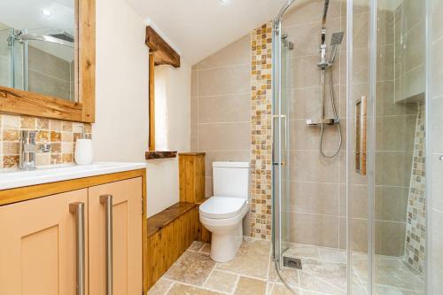 a bathroom with a toilet and a glass shower at Cornwall cottage The Old Piggery in Liskeard