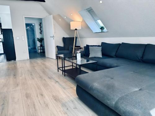 een woonkamer met een blauwe bank en een glazen tafel bij FeWo Lindenallee II in Nordhorn