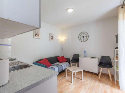 une cuisine et un salon avec un canapé dans l'établissement Appartement 32 m² avec balcon, proche télécabine et commodités, entièrement équipé, centre Cauterets - FR-1-401-237, à Cauterets