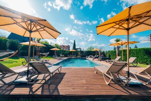 a swimming pool with chairs and umbrellas at Babil Bungalow Boutique Hotel in Kartepe