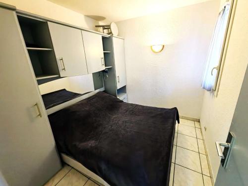 - une petite cuisine avec un lit dans une chambre dans l'établissement Charmant T2 en Pinède avec parking, véranda et terrasse, à 900m de la plage, idéal pour 4 personnes - FR-1-607-41, au Cap d'Agde
