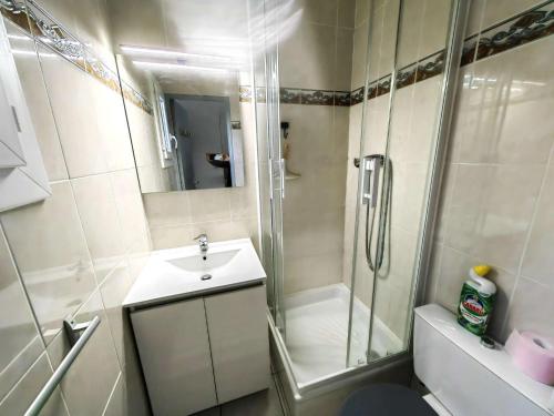 une salle de bain blanche avec une douche et un lavabo dans l'établissement Charmant T2 en Pinède avec parking, véranda et terrasse, à 900m de la plage, idéal pour 4 personnes - FR-1-607-41, au Cap d'Agde