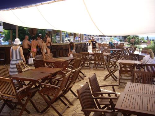 a group of people walking around a patio with tables and chairs at Relaks w Marina Cape 88 in Aheloy