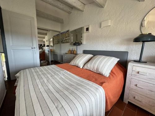 une chambre avec un lit avec une couverture orange et blanche dans l'établissement Mas 2 chambres avec vue mer, piscine, Wi-Fi - FR-1-726-10, à La Croix-Valmer