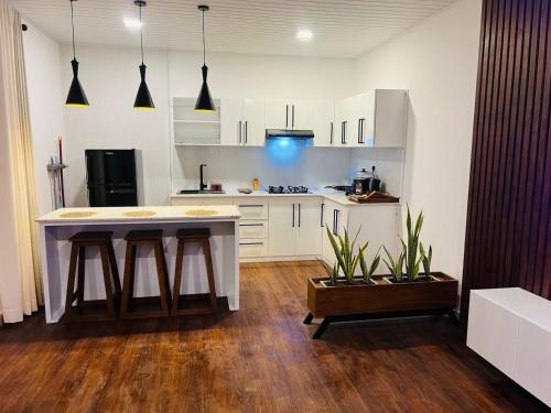 a kitchen with white cabinets and a table with two stools at Apartment lake kurunegala in Kurunegala