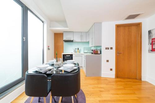 a dining room with a table and chairs and a kitchen at Piccadilly Circus-West End Central London Studio Apartment in London