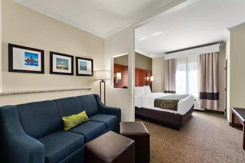 a hotel room with a couch and a bed at Comfort Suites Central in Corpus Christi