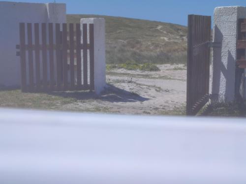 een open poort op een strand met een hek bij Coruña Backpackers Hostel in Carballo