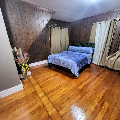 Opulence Living close to Boston في ستوكتون: غرفة نوم بسرير وارضية خشبية