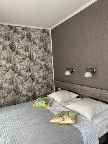 a bedroom with two beds with pillows and a wallpaper at Yurus Hostel in Lviv