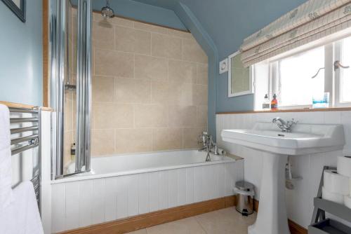 a bathroom with a sink and a bath tub and a sink at The Stables Loft, Close to Elie Beach in Elie