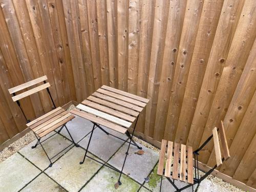 a wooden fence with two chairs and a bench at Bath rd villa in Keynsham