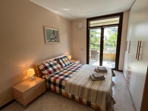 een slaapkamer met een bed en een raam bij DISCOVERY FLAT with pool & bikes in Sirmione