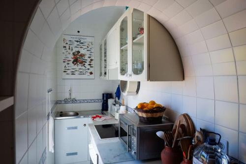 eine Küche mit einem Bogenbogen und eine Küche mit einer Spüle in der Unterkunft Casa Avelar in Tavira