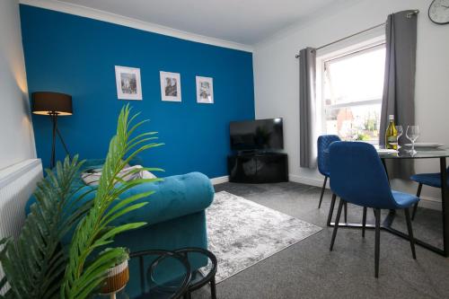 sala de estar con paredes azules y sofá azul en Inviting 2-Bed apartment - Perfect for Contractors and Business Travellers en Retford
