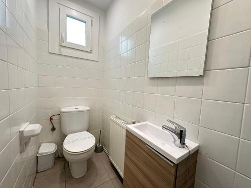 a white bathroom with a toilet and a sink at Agi Ferran 32 in Roses