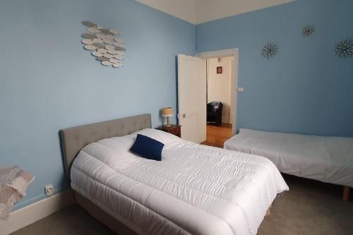 - une chambre avec 2 lits et un mur bleu dans l'établissement Appartement 5 pers, à 200 m de la plage de Wimereux - Chalet Valentine, à Wimereux