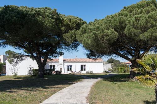 uma casa branca com árvores em frente em Villa Kenavo - Maison familiale avec vue mer em Île dʼAix